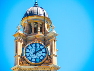 Close-up Clock tower at Sydney Central railway station with blue sky at the background.