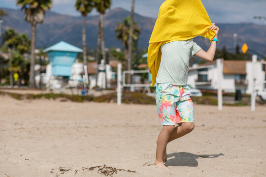 Funny boy playing with beach towel