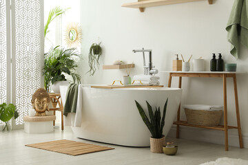 Stylish bathroom interior with modern tub, houseplants and beautiful decor. Home design