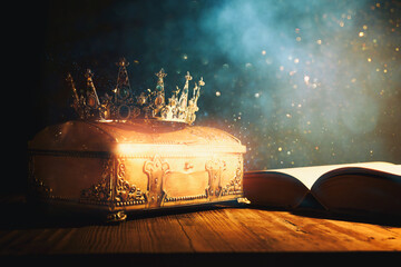 low key image of beautiful queen or king crown and old book. vintage filtered. fantasy medieval period