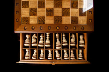 White chess pieces are stacked in a box. A puzzle game with tricky combinations that requires planning and thinking.