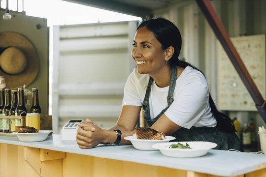 Smiling female entrepreneur looking away in food truck