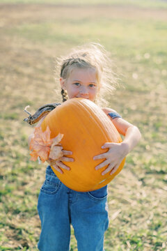 farm girl holding pumpkin