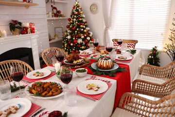 Festive dinner with delicious food and wine on table indoors. Christmas Eve celebration