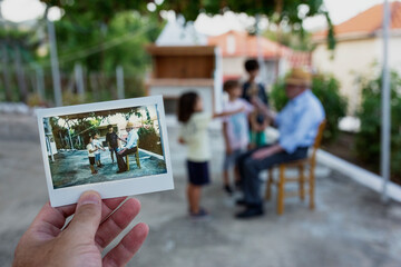 Man's hand holding instant photo