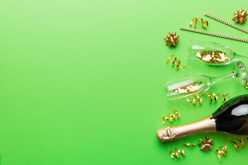 Champagne bottle, glitter and straws on color background. top view. Hilarious, christmas and birthday celebration