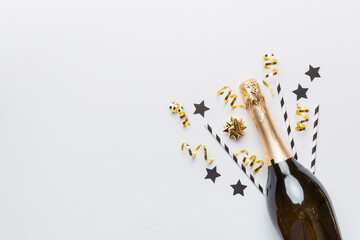 bottle of champagne with glasses and colorful confetti on colored background. top view flay lay