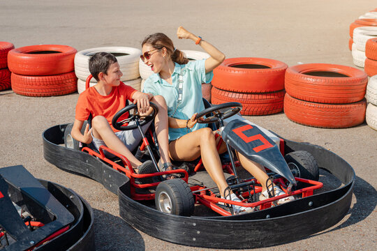 Mom and son have fun and go karting. Joint leisure for two and motorsport classes