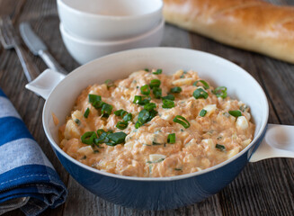 Seafood salad in a bowl. Made with salmon, boiled eggs, mayonnaise, onions and chives