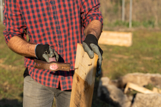 Crop image of Man removing nails from pallet outdoors