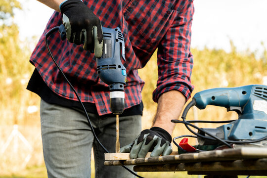 Man drilling wooden designed board 