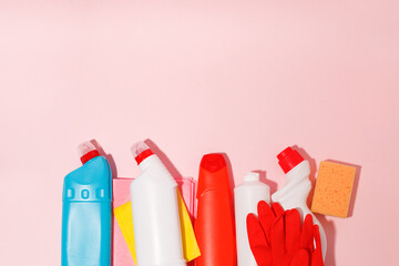 Chemical poisoned cleaning supplies bottles isolated on pink pastel background. Hard shadow, trendy shot, copy space for your adds, cleaning service flyer, coupon, banner