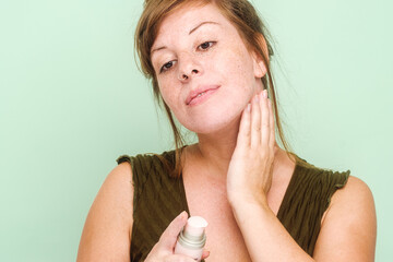 Woman With Freckles Using Skincare Product On Her Neck