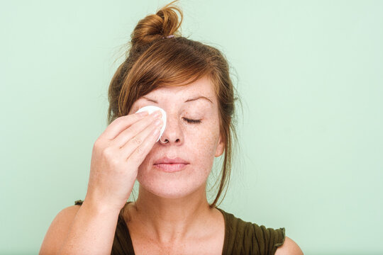 Woman With Freckles Removing Makeup From Her Eyes