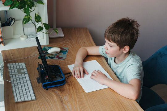 Young Schoolboy Studies From Home.