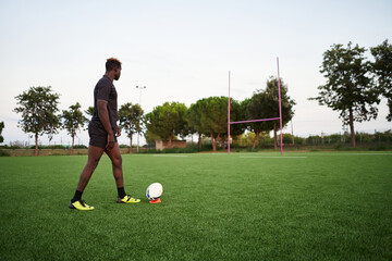 Black rugby player exercising in field