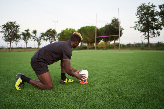 Black rugby player exercising in field