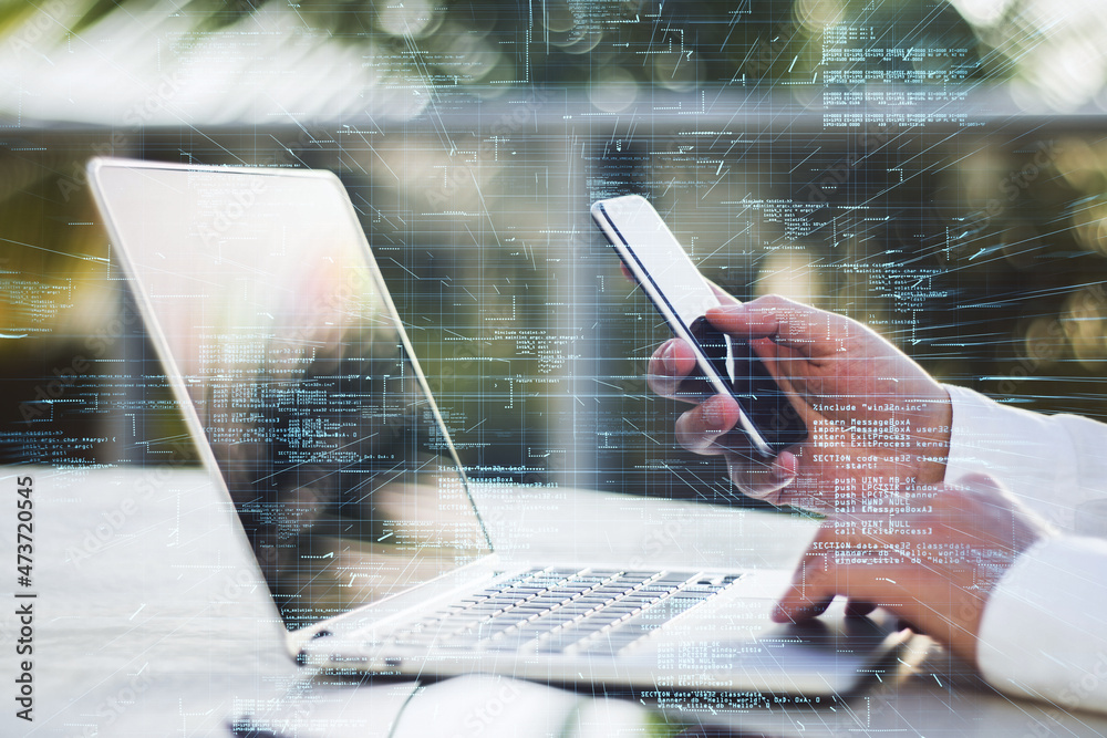 Poster Close up of businessman hands using laptop and smartphone with creative glowing coding big data interface on blurry outdoor background. Technology and futuristic network. Double exposure.