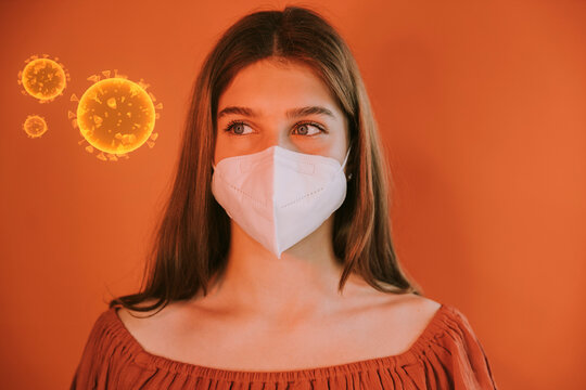 Girl wearing protective face mask by COVID-19 virus against red background