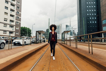 Young woman walking on tramway in city