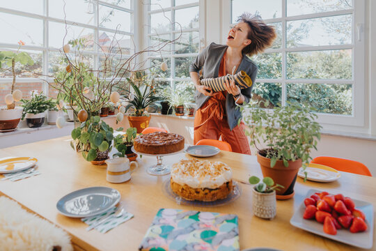 Carefree woman playing with wrapped gift by during Easter at home