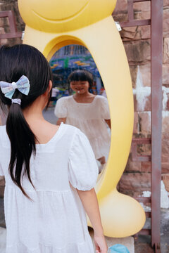 kid playing in front of distorting mirror