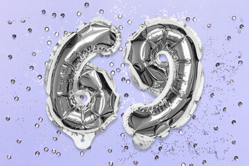 Silver foil balloon number, digit sixty nine on a lilac background with sequins. Birthday greeting card with inscription 69. Top view. Numerical digit. Celebration event, template.