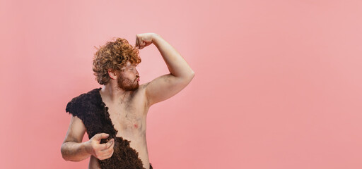 Cropped portrait of artistic man in charater of neanderthal showing muscles, strength posing...