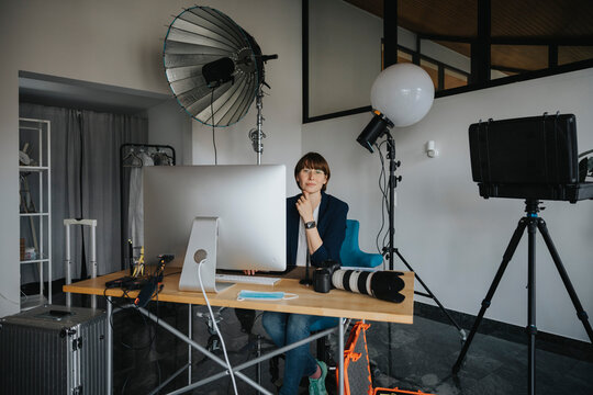 Female photographer sitting at desk in studio