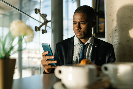 Man at the bar with his smart phone and drinking coffee