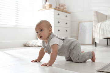 Cute baby crawling on floor at home
