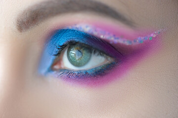 Bright blue eye makeup with sparkles closeup