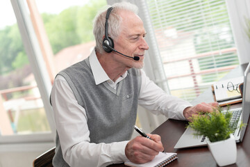 Businessman talking on a headset and using a laptop