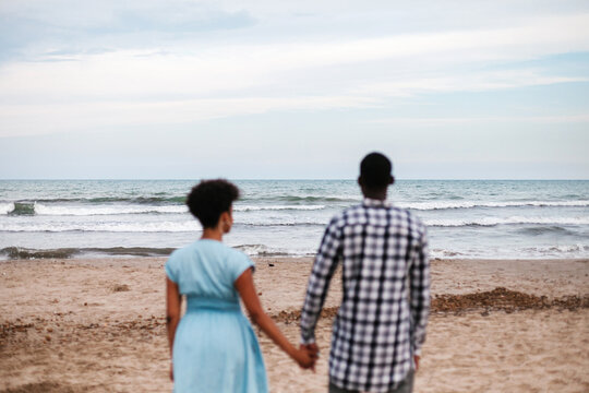 Loving couple tenderly holding hands at seaside