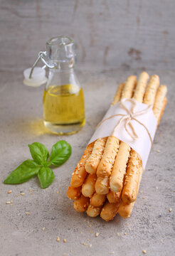 Grissini sticks. Traditional italian bread sticks with sesame seeds on a gray background
