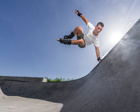 Man doing balancing stunt in roller skates on sunny day