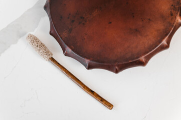 Shaman tambourine and drumstick on table