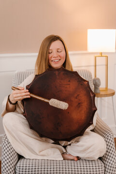 Serene woman playing shaman tambourine