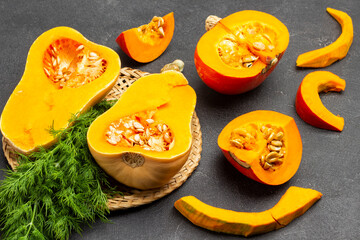 Two halves of pumpkin and dill on wicker plate.