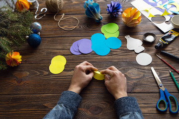 Making paper ornaments in the form of honeycombs for a Christmas tree. Origami. Manufacturing manual, instructions, step by step No. 4. Bend the circles in half. Handmade, DIY. Selective focus.