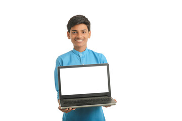 Indian child wearing traditional cloth and showing laptop screen