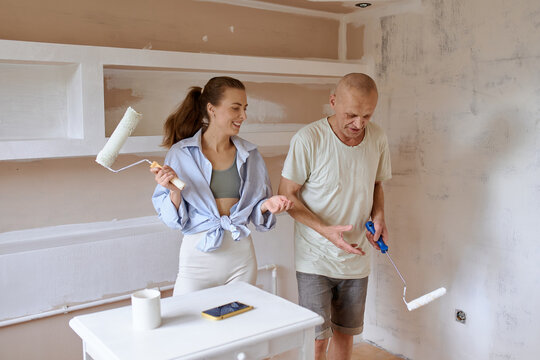dad and daughter paint the walls white