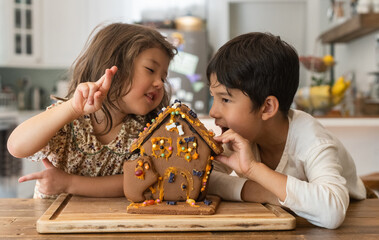 Happy kids with gingerbread house