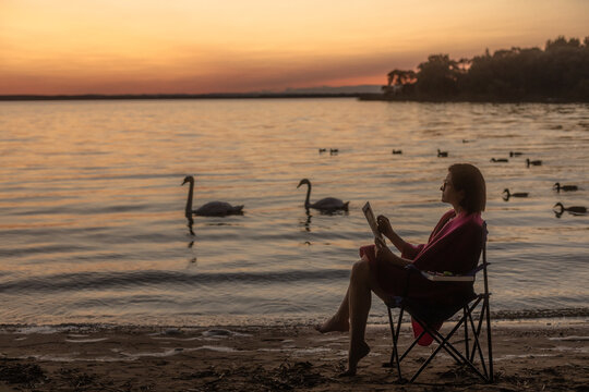 a girl draws on the sunset shore