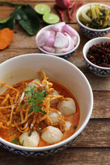 Local northern Thai food Egg noodle curry with meatballs on wood background