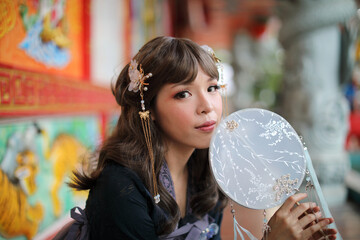 Naklejka premium Beautiful young woman with dark blue Chinese lolita dress with Chinese garden