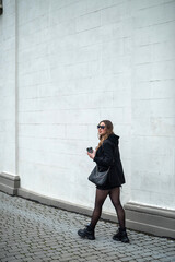 beautiful young girl in autumn style clothes on the city street.