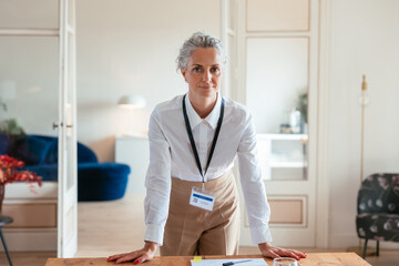Confident female boss leaning on table