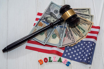 on the American flag, brand new dollars with a judge's gavel spread out on a spacious table