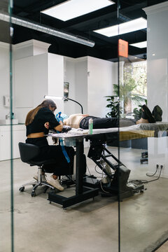 Woman doing tattoo to client